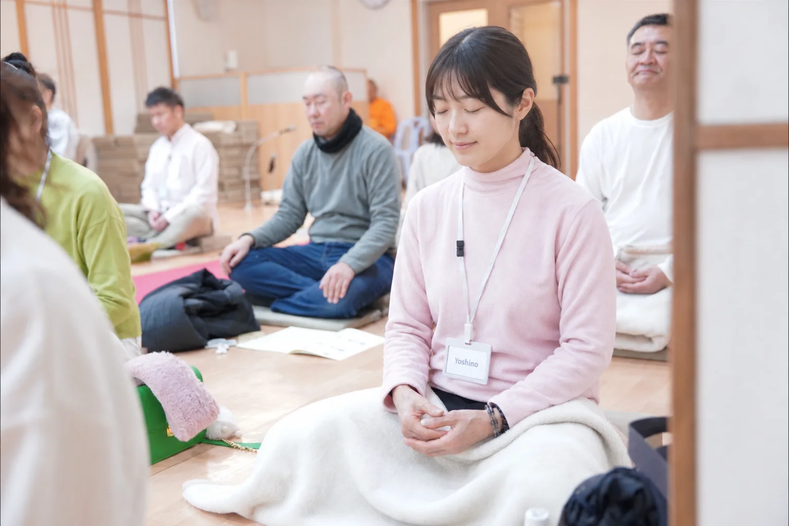 Young Japanese woman meditating peacefully — face adjusted with AI for privacy